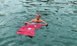Soğuk ve yağışlı havaya aldırmadı, Türk bayrağıyla denize girdi